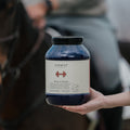 Person holding a jar labeled 'Body&Build Curafyt" with a blurred background